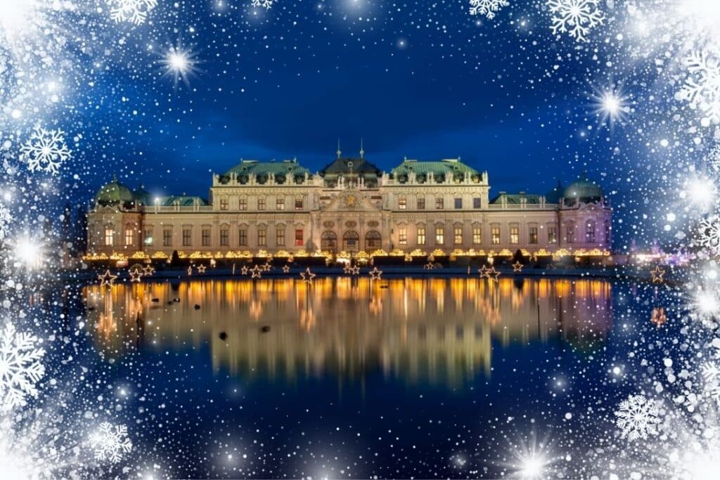 Ein prächtiger, beleuchteter Palast bei Nacht spiegelt sich in einem ruhigen See, umgeben von funkelnden Lichtern und festlichen Dekorationen, und weiße Schneeflocken umrahmen die Szene.