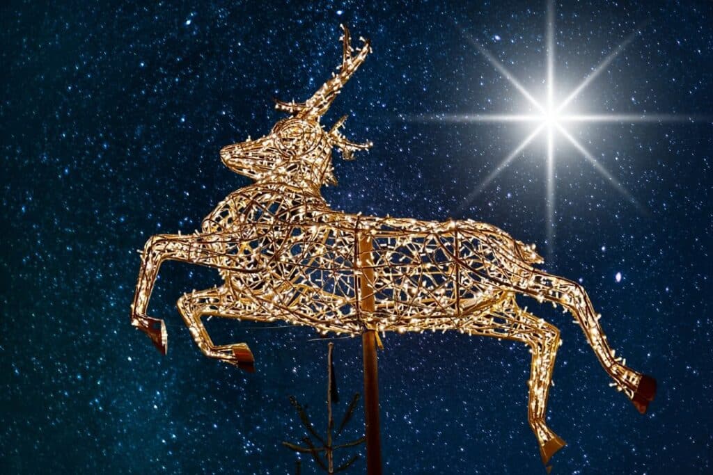 Eine leuchtende Rentierskulptur aus goldenen Lichtern scheint gegen einen sternenklaren Nachthimmel zu springen, mit einem hell leuchtenden Stern im Hintergrund.