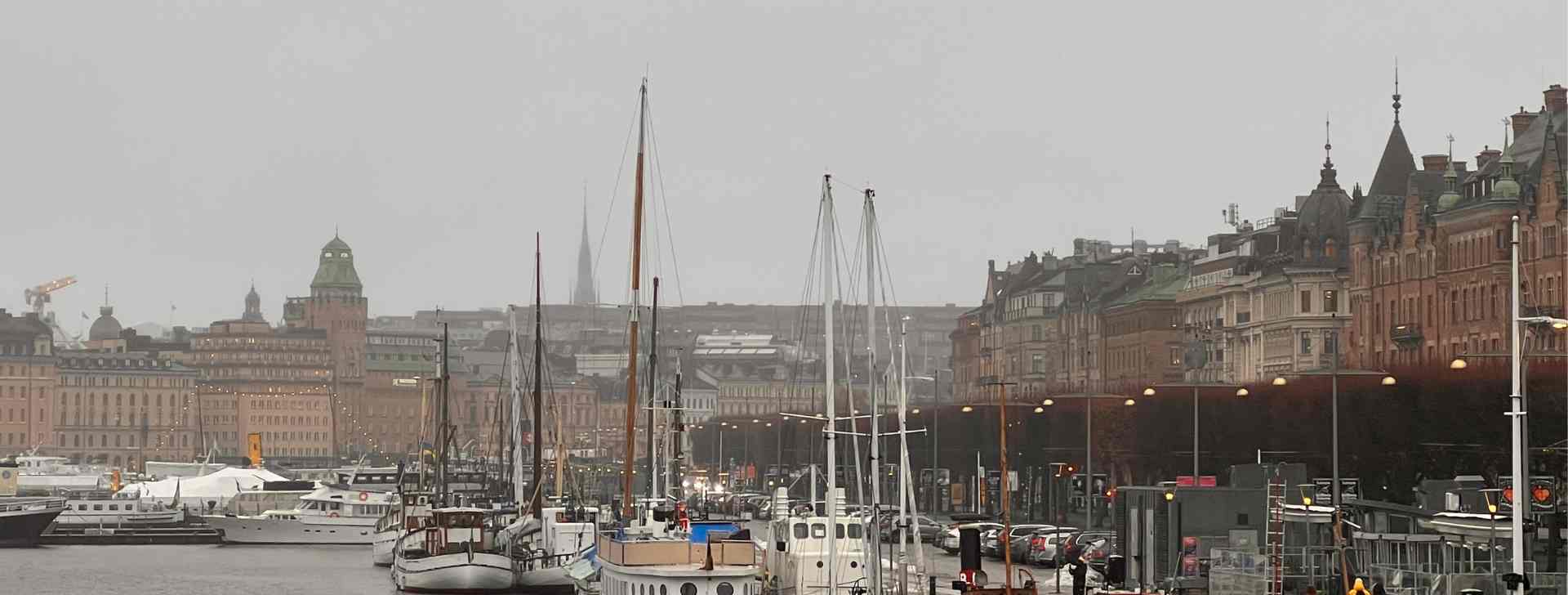 Stockholm vom Wasser aus - im Vordergrund sieht man Schiffe im Hintergrund die imposanten Bauwerke Stockholms