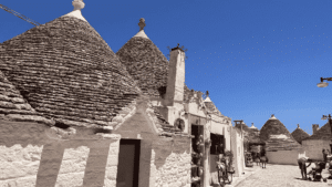 eine malerische Gasse in Alberobello - man sieht viele Trulli-Häuser